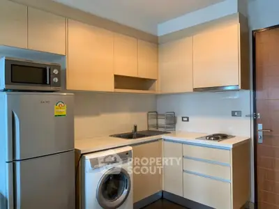 Modern kitchen with appliances including fridge, microwave, and washing machine.