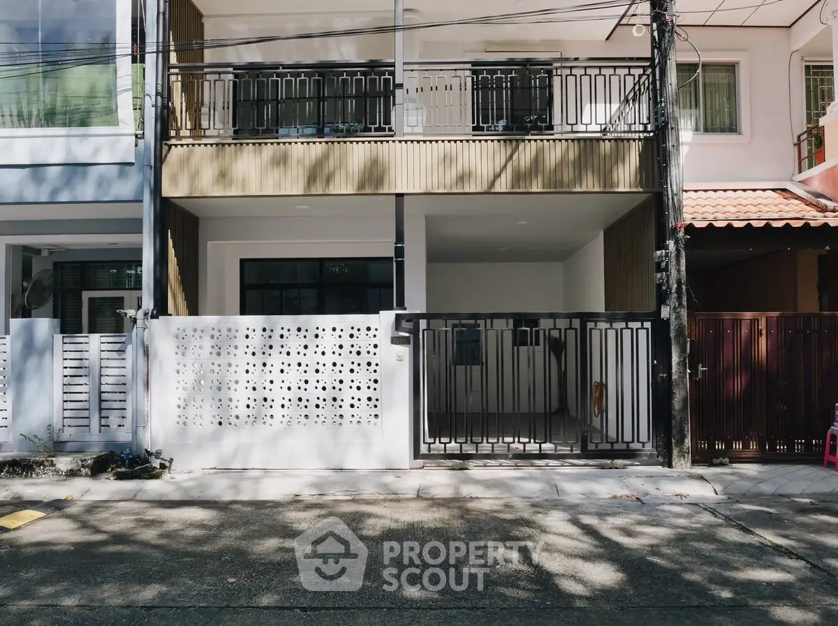 Modern townhouse exterior with stylish facade and gated entrance in urban setting.