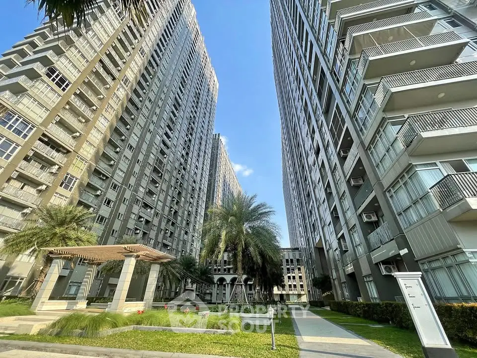 Stunning high-rise residential complex with lush landscaping and modern architecture.