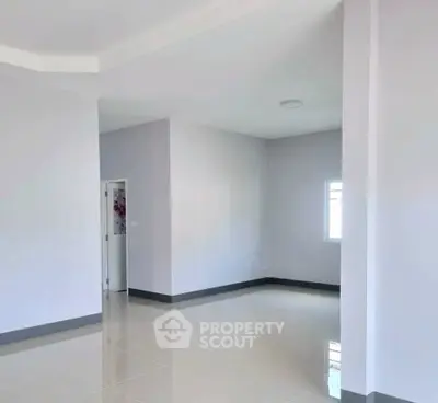 Spacious empty room with glossy tiled flooring and white walls, perfect for customization.