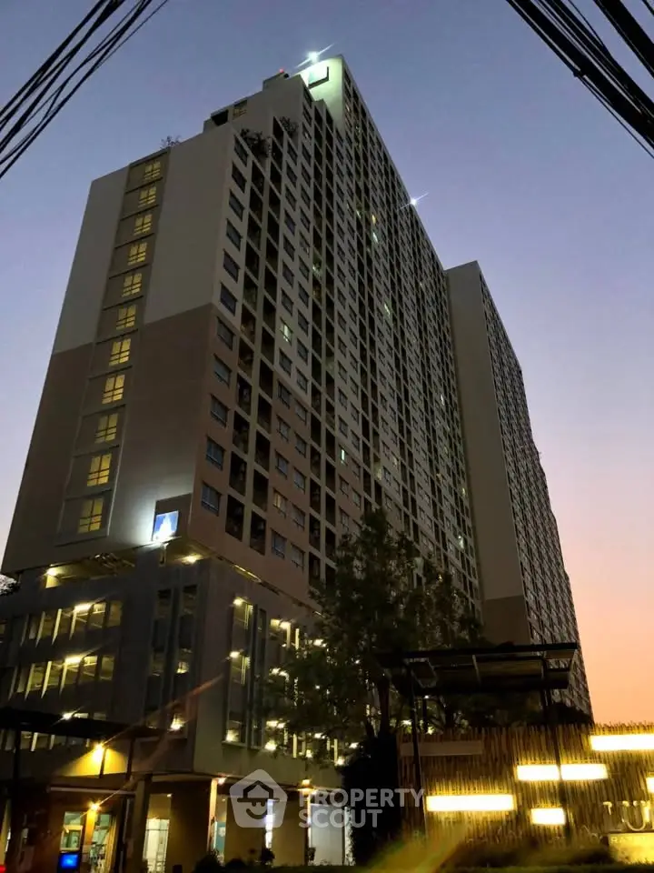 Stunning high-rise building at dusk with illuminated windows and modern architecture.
