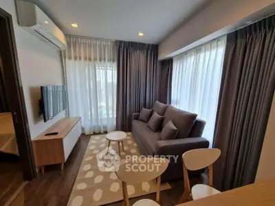 Modern living room with cozy sofa, stylish decor, and natural light through large windows.