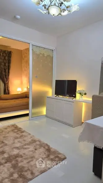 Cozy living room with modern decor and ambient lighting, featuring a TV and plush rug.