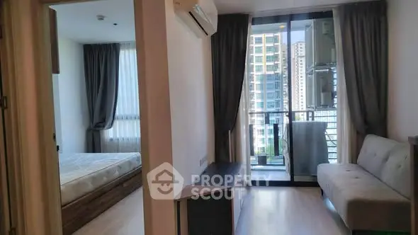 Modern apartment with balcony and city view, featuring a cozy living area and bedroom.