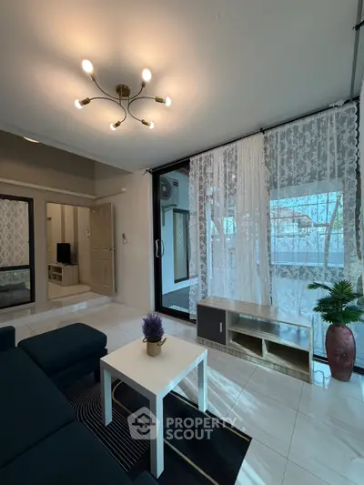 Modern living room with stylish lighting and large windows offering natural light.
