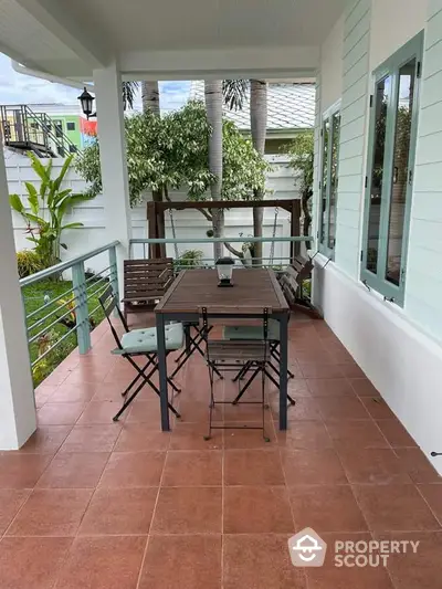 Charming balcony with garden view and stylish outdoor furniture, perfect for relaxation and entertaining.