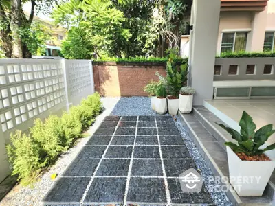 Charming garden area with modern landscaping and potted plants in a residential setting.