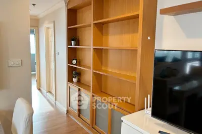 Spacious living room with wooden shelving and modern TV setup, perfect for cozy family gatherings.
