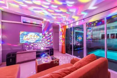 Vibrant living room with colorful lighting and pool view, perfect for entertainment and relaxation.