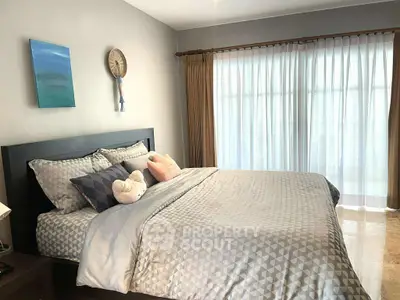 Cozy bedroom with large window and stylish decor, perfect for relaxation.