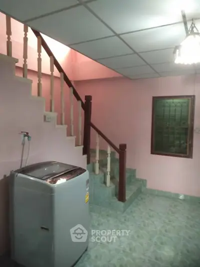 Charming interior with staircase and washing machine, ideal for practical living.