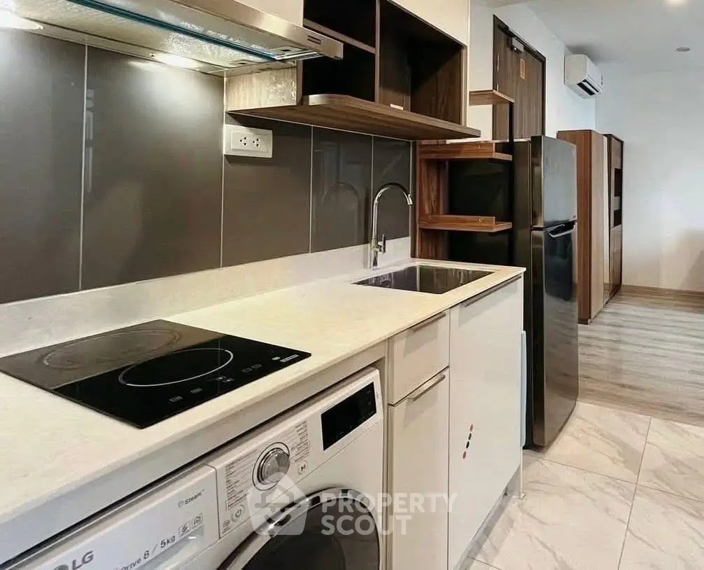 Modern kitchen with sleek appliances and stylish cabinetry in a contemporary apartment.