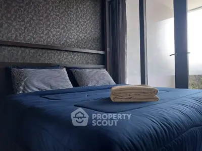 Cozy bedroom with elegant decor and large windows for natural light.