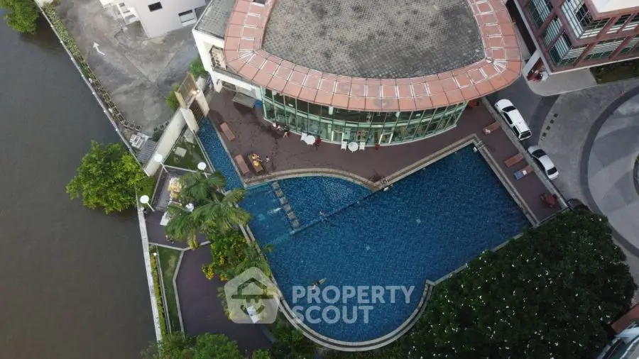 Stunning aerial view of luxury riverside building with pool