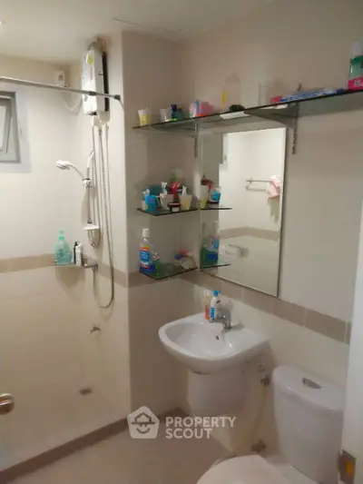 Modern bathroom with shower, sink, and toilet in a compact layout.