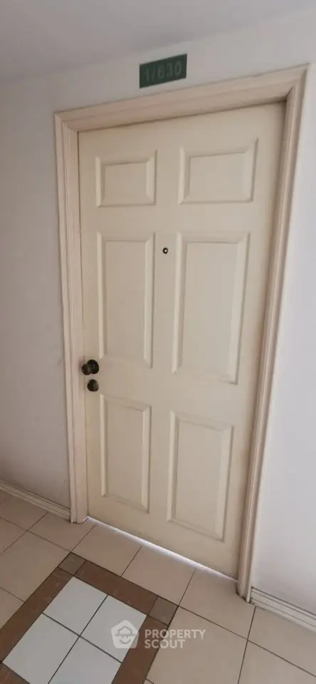 Elegant apartment entrance with classic cream door and tiled floor