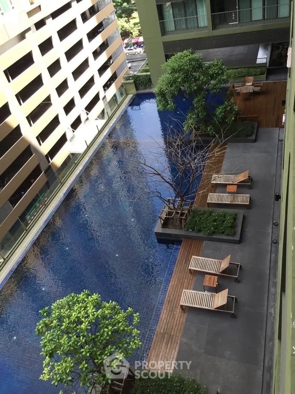 Luxurious apartment complex with stunning outdoor pool and lush greenery, perfect for relaxation and leisure.