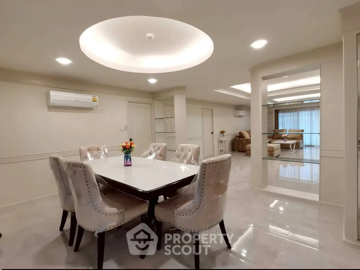 Elegant dining area with modern lighting and plush seating in a spacious open-plan layout.