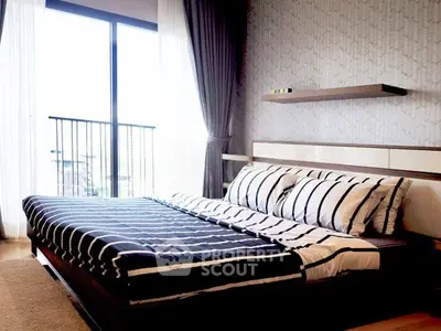 Modern bedroom with stylish decor and large window offering natural light and balcony view.