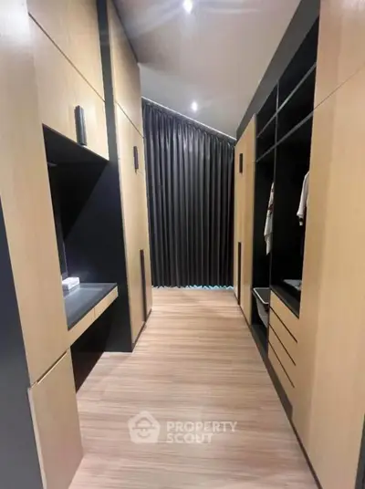 Spacious modern walk-in closet with sleek wooden cabinetry and ample storage space.