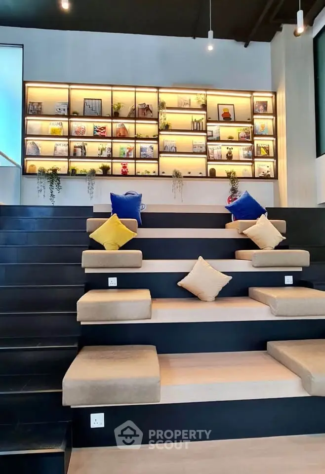 Modern co-working space with tiered seating and stylish bookshelf display.