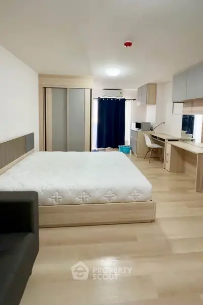Spacious modern bedroom with study area and natural light, perfect for urban living.