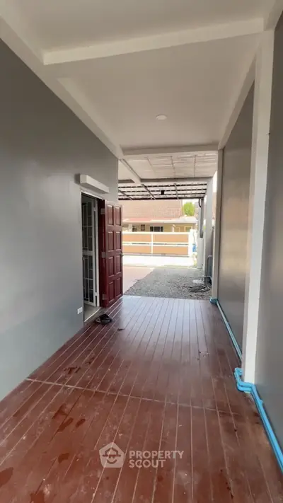 Spacious covered entrance with wooden flooring and modern design