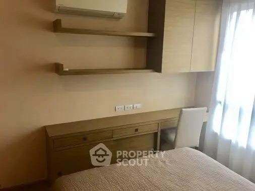 Cozy bedroom with built-in desk and shelves, perfect for a compact living space.