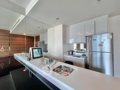 Modern kitchen with sleek design, featuring stainless steel appliances and a spacious countertop.