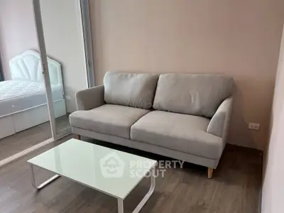 Modern living room with cozy gray sofa and sleek glass coffee table