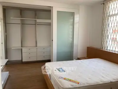 Spacious bedroom with built-in closet and large window for natural light.