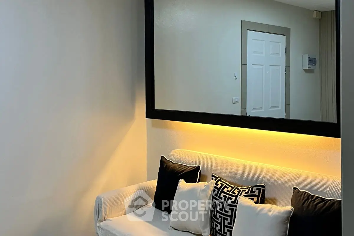 Stylish living room with elegant sofa and decorative pillows under ambient lighting.