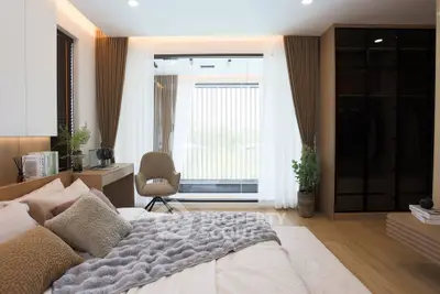 Luxurious bedroom with modern decor and large window offering natural light