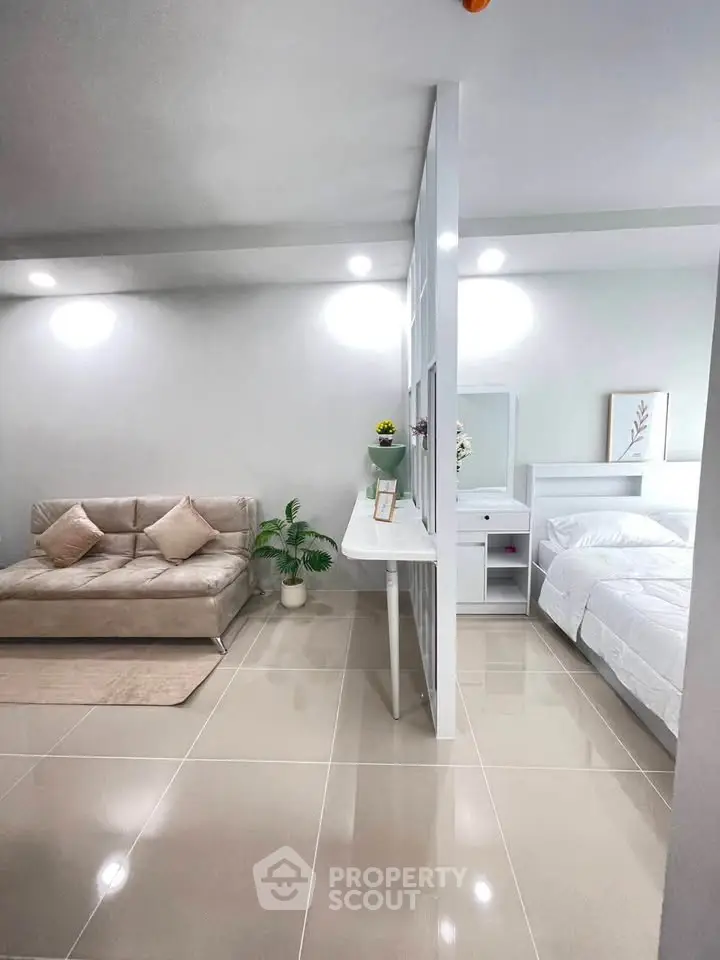 Modern studio apartment with sleek design, featuring a cozy living area and comfortable bed.