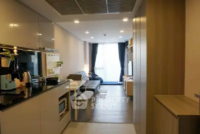 Modern open-layout kitchen and living room with sleek design and natural light.