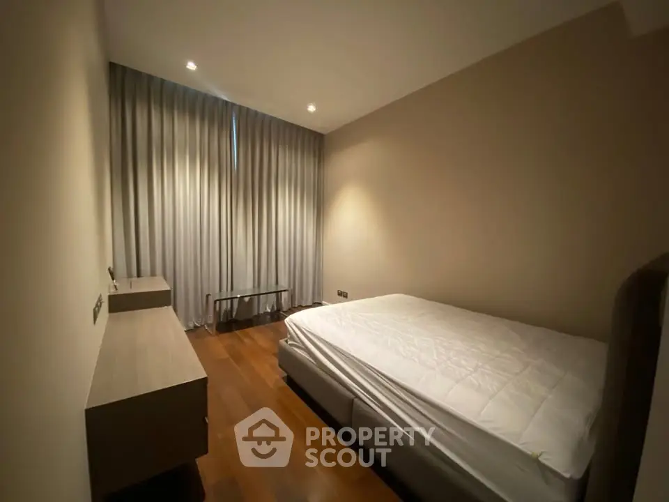 Cozy bedroom with elegant wooden flooring and soft lighting, perfect for relaxation.