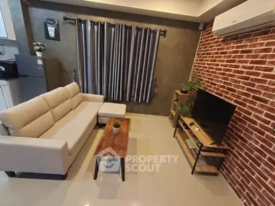 Modern living room with stylish brick wall and cozy furniture setup.