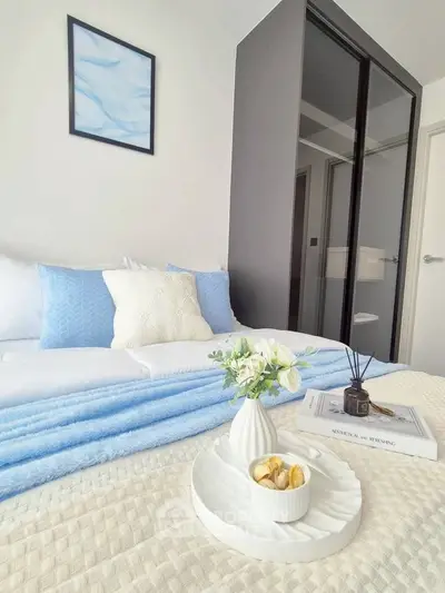 Cozy bedroom with modern decor and soft blue accents, featuring a stylish bed and elegant furnishings.