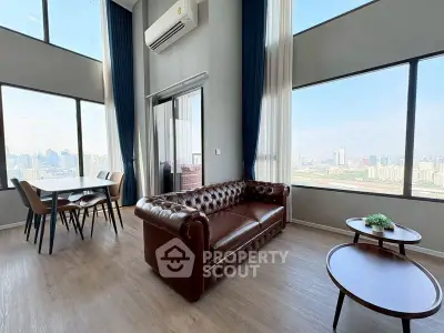 Luxurious high-rise living room with stunning city views and elegant leather sofa.