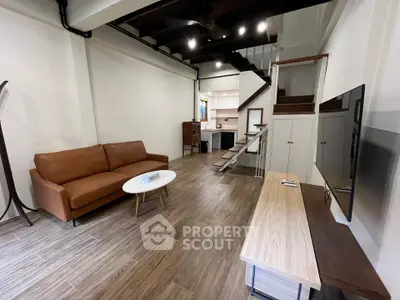 Modern living room with stylish furniture and open staircase in a contemporary home.