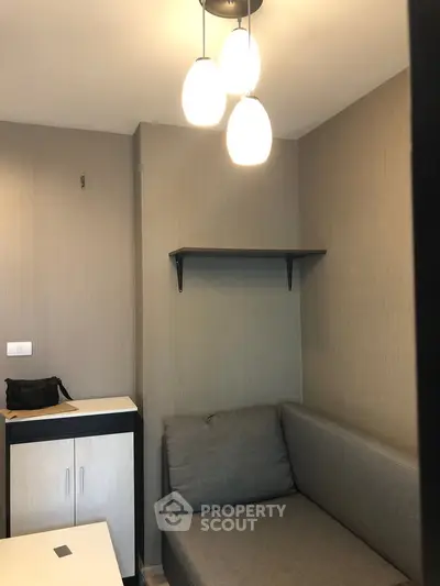 Cozy modern living room with stylish lighting and compact sofa, perfect for urban living.