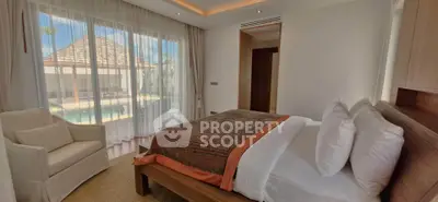 Luxurious bedroom with pool view in modern villa, featuring elegant decor and abundant natural light.