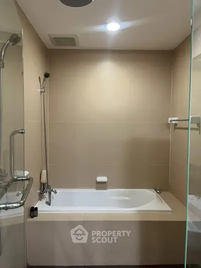 Modern bathroom with sleek bathtub and glass shower enclosure