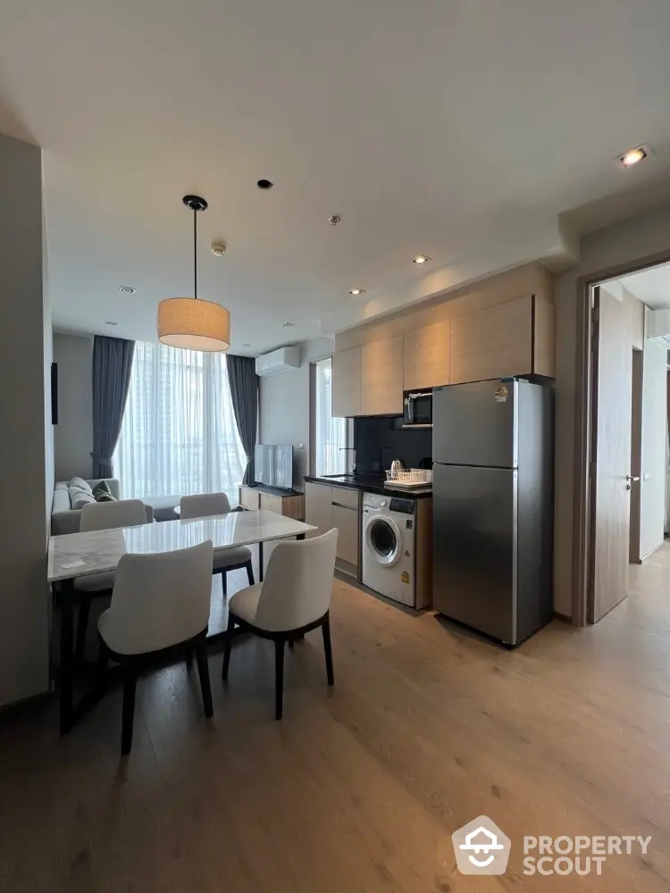 Modern open-plan kitchen and dining area with washing machine and fridge