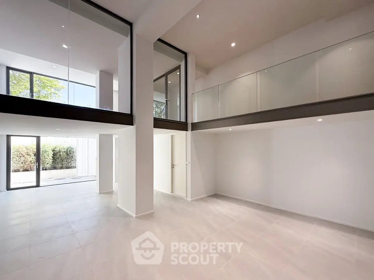 Spacious modern living room with high ceilings and large windows offering natural light.