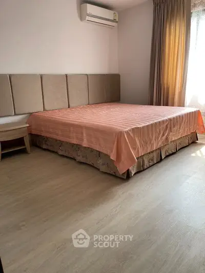 Spacious bedroom with elegant decor and natural light, featuring a comfortable bed and stylish furnishings.