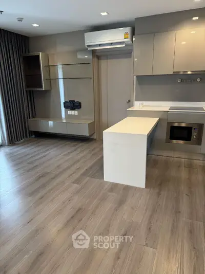Modern kitchen with sleek cabinetry and built-in microwave in a stylish apartment.