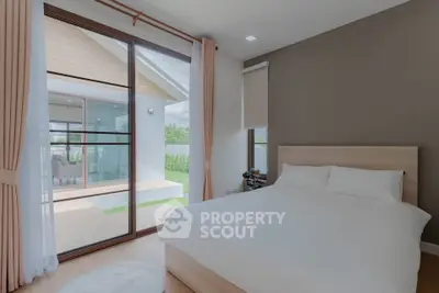 Spacious bedroom with large windows and balcony access in modern home.