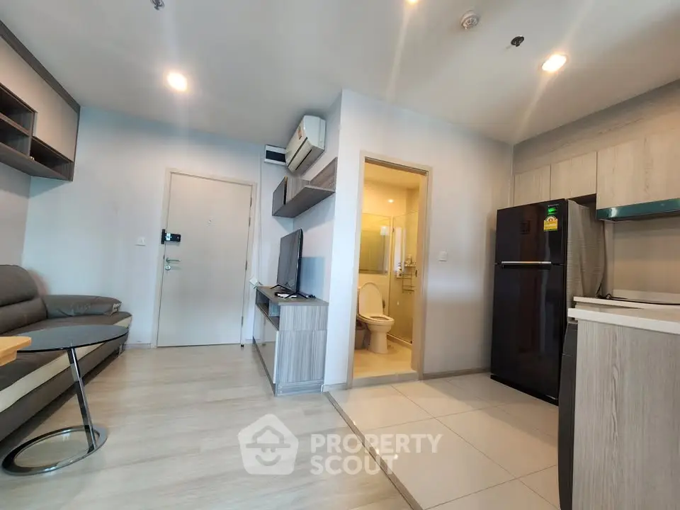 Modern apartment interior with open layout, featuring cozy living area and sleek kitchen design.