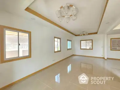 Spacious empty living room with modern ceiling light and large windows